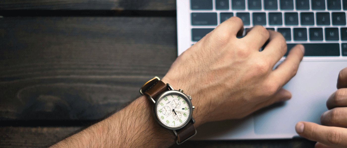 person using laptop with watch on wrist