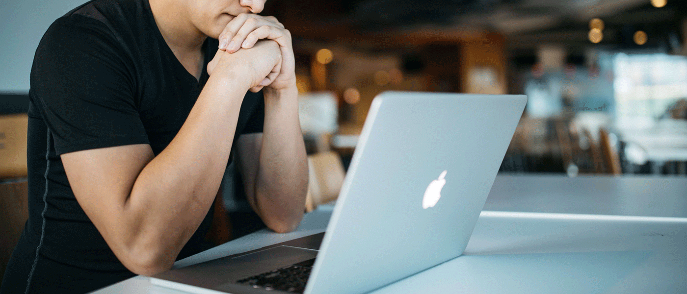 Man looking at macbook screen