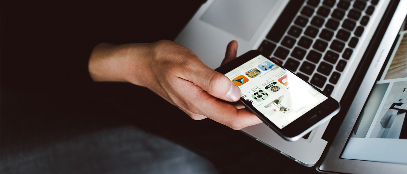 Person using phone and macbook